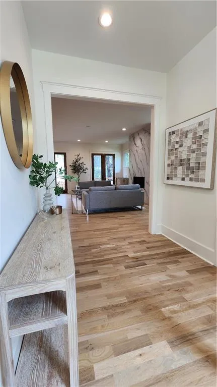 Hallway with light wood finished floors and recessed lighting