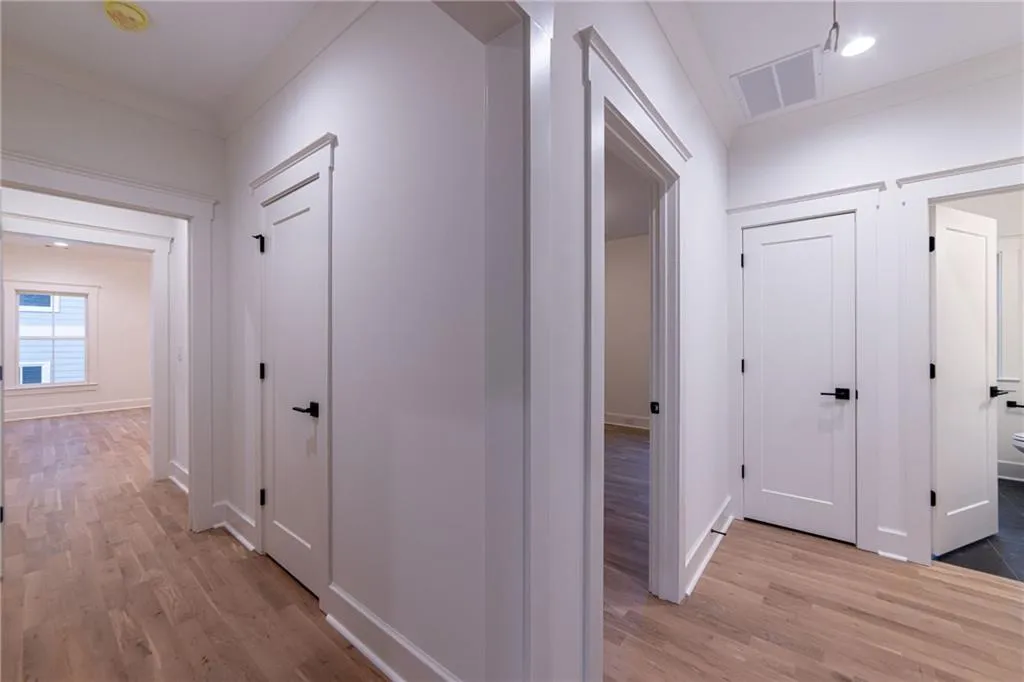 Corridor with light wood-style floors and recessed lighting