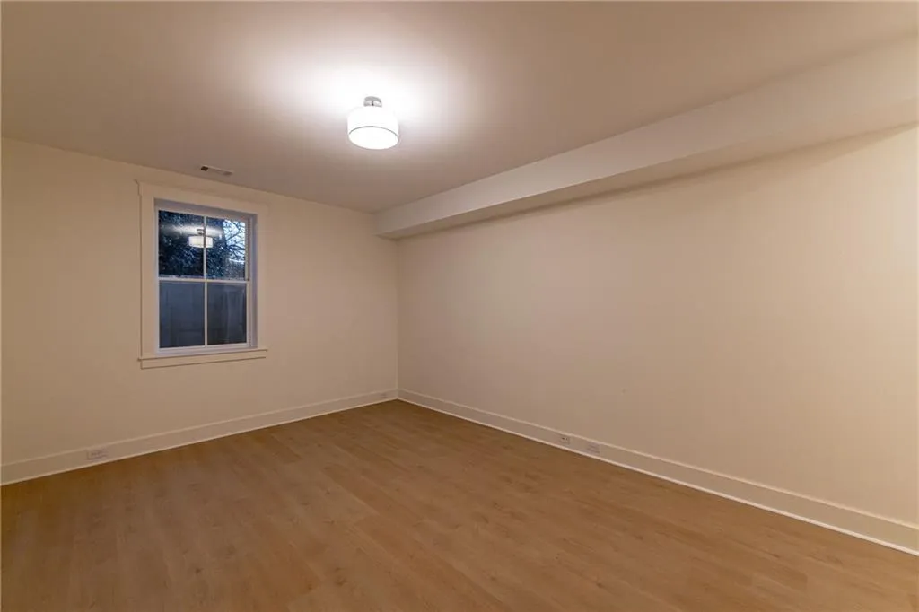 Empty room with baseboards and light wood-type flooring