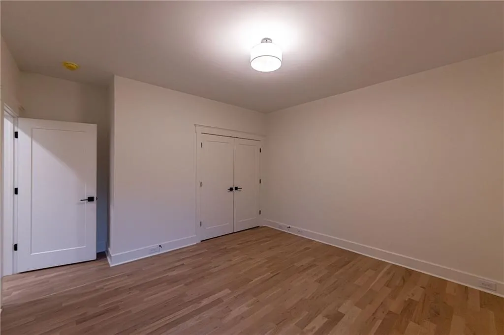 Unfurnished bedroom featuring wood finished floors and a closet