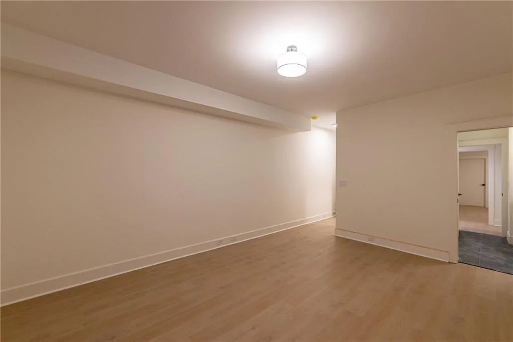 Unfurnished room with wood finished floors and baseboards