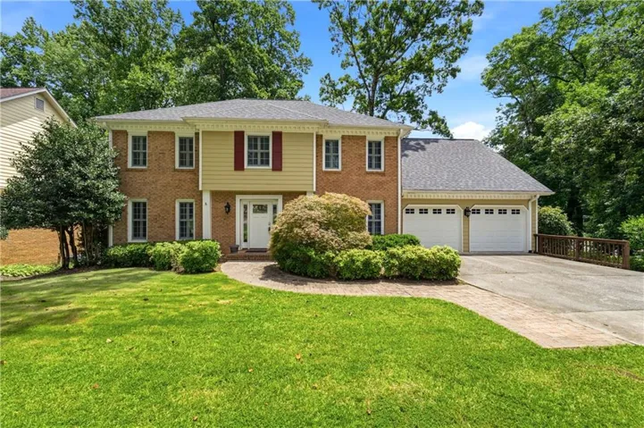 Brick facade with light yellow siding accents and a contrasting dark gray shingle roof