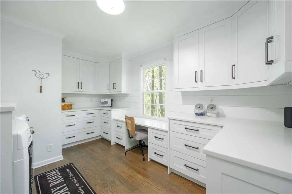 Office space with dark hardwood / wood-style flooring and ornamental molding