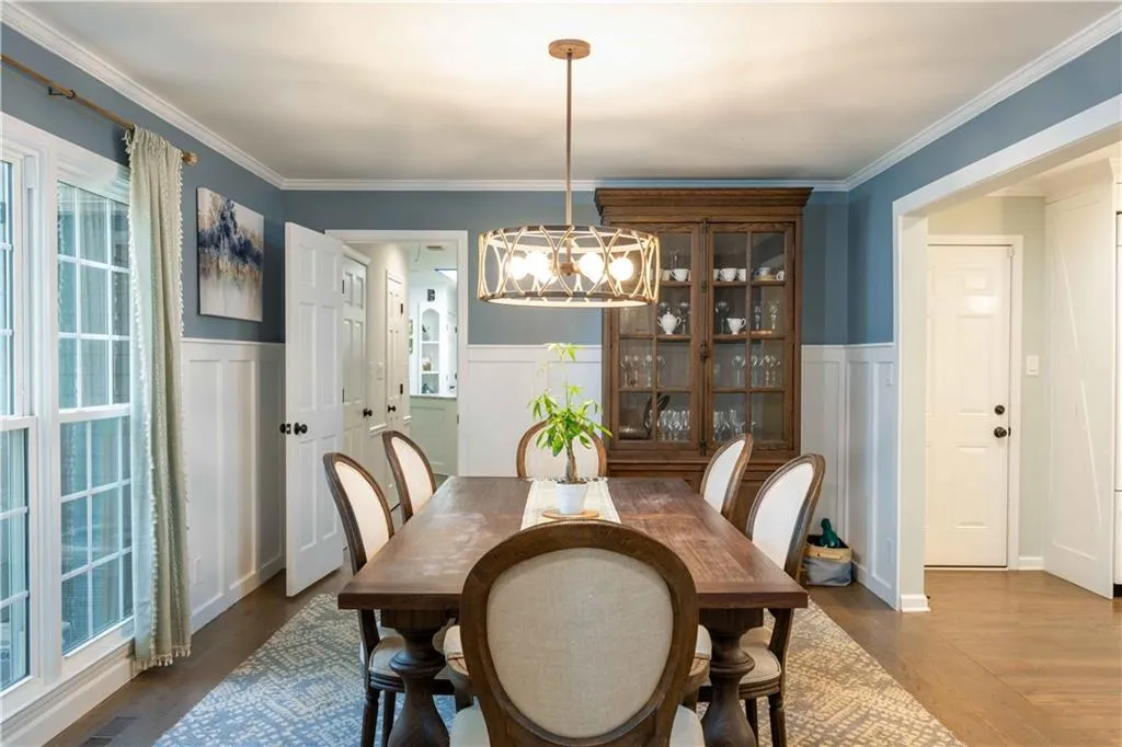 Dining space with crown molding, dark hardwood / wood-style flooring, and a chandelier