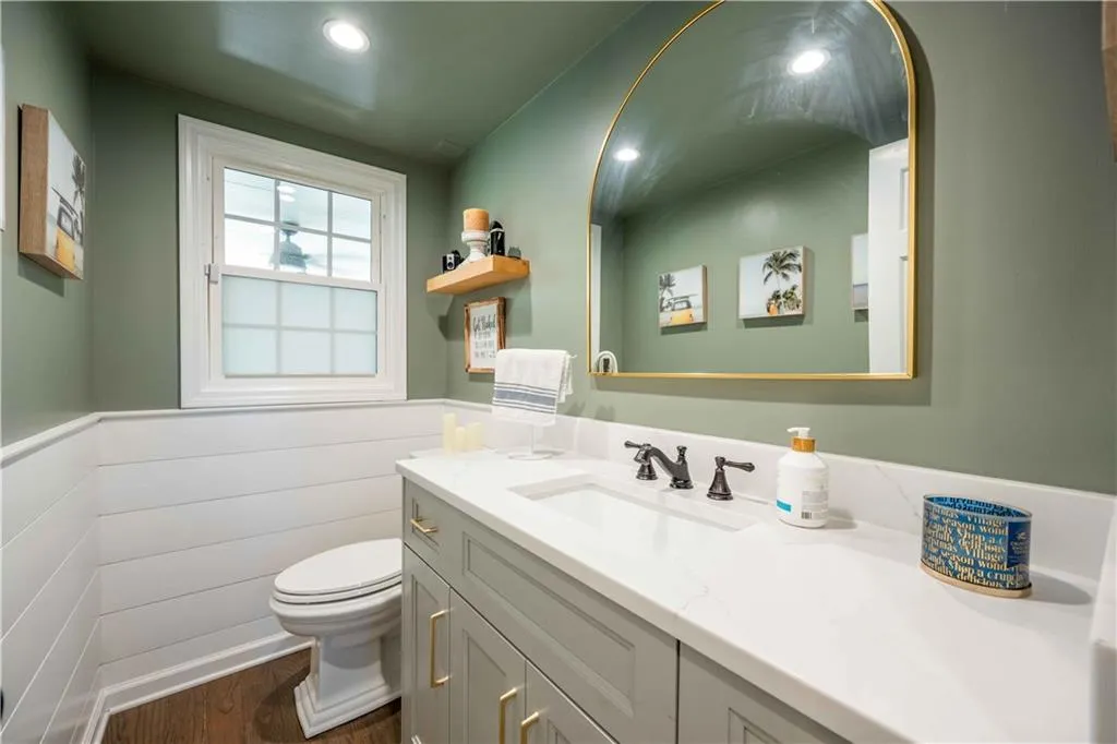 Bathroom with hardwood / wood-style floors, toilet, and vanity