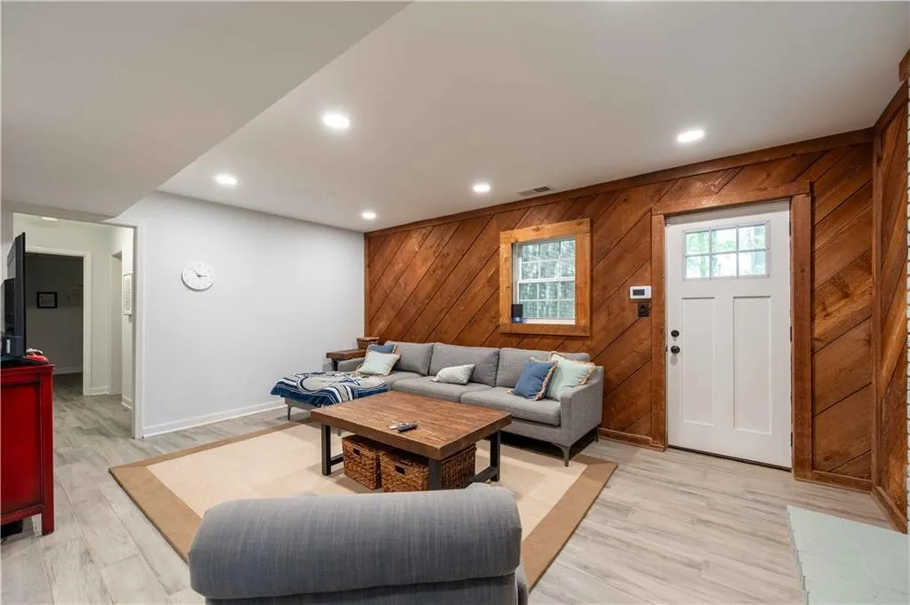 Living room with wood walls and light hardwood / wood-style flooring