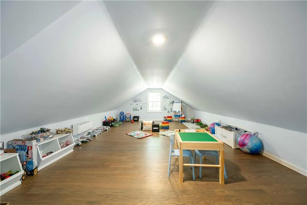 Game room featuring dark hardwood / wood-style flooring and vaulted ceiling