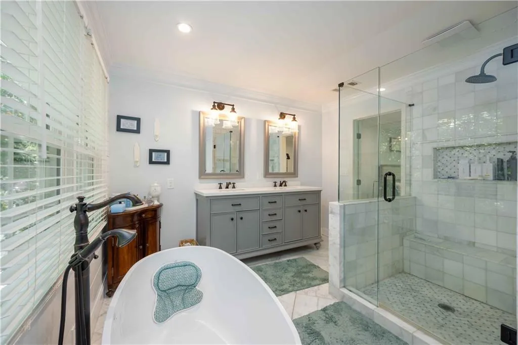 Bathroom featuring ornamental molding, double sink vanity, tile flooring, and separate shower and tub