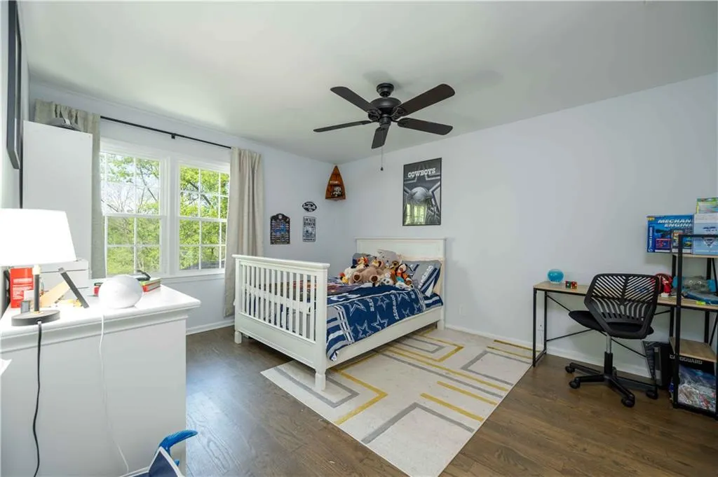 Bedroom with dark hardwood / wood-style floors and ceiling fan