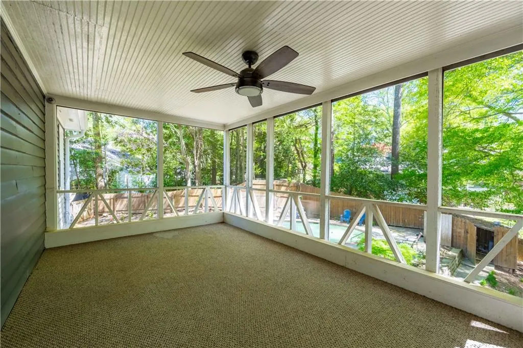 Unfurnished sunroom with ceiling fan and a wealth of natural light
