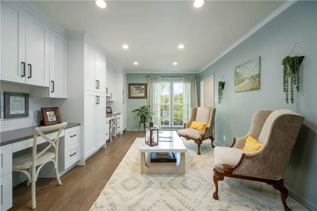 Sitting room with dark hardwood / wood-style flooring and ornamental molding