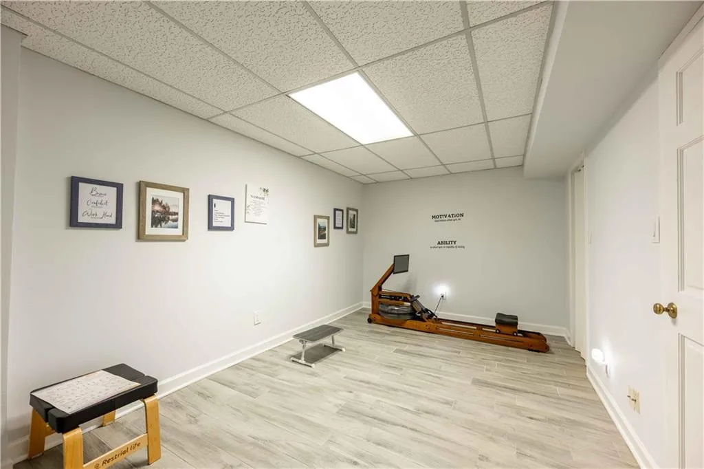 Exercise room featuring light hardwood / wood-style flooring and a drop ceiling