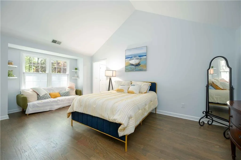 Bedroom featuring dark hardwood / wood-style flooring and vaulted ceiling