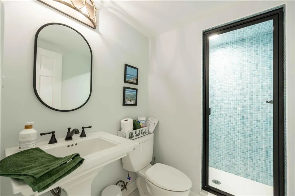Bathroom featuring a shower with shower door and toilet