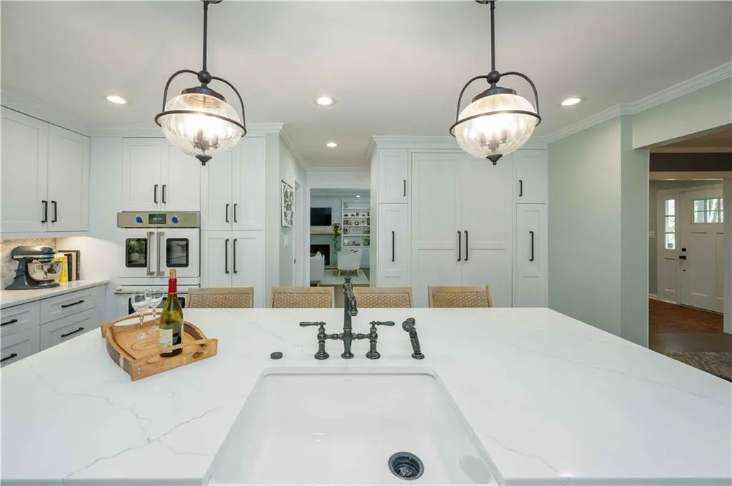 Kitchen with light stone countertops and decorative light fixtures