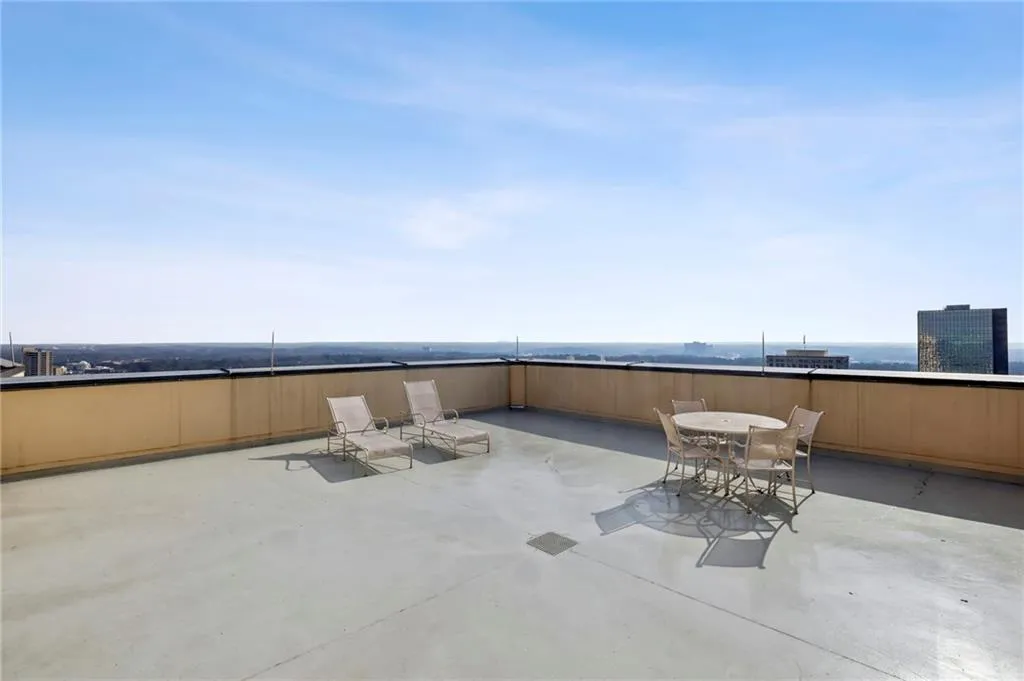 Expansive rooftop terrace featuring a light-colored concrete surface and a surrounding parapet wall