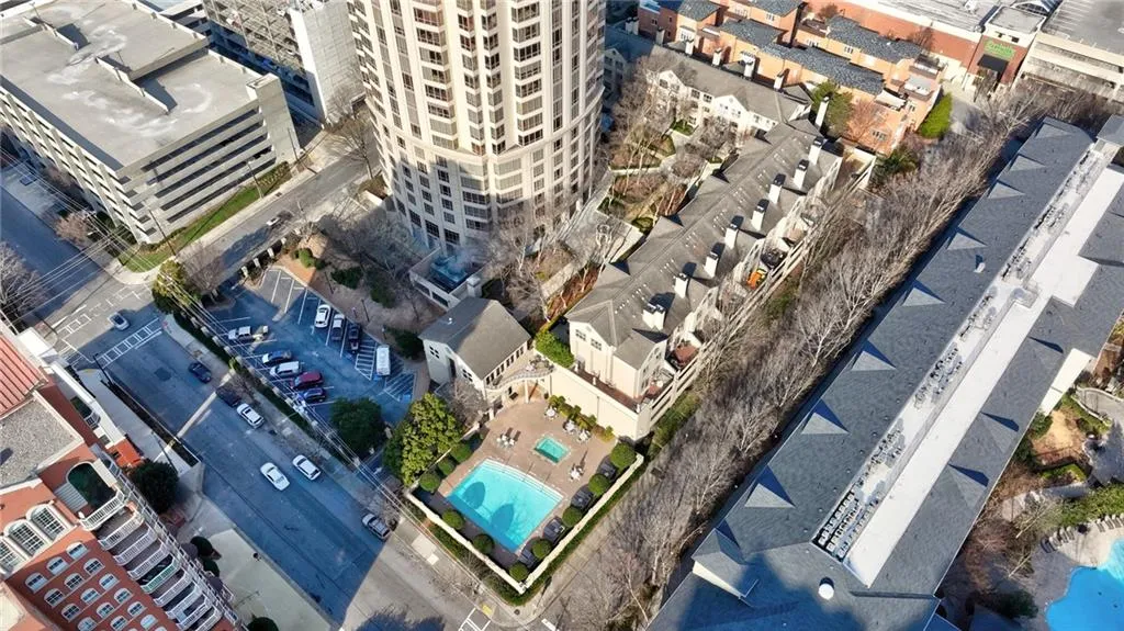 Aerial depiction of a residential complex featuring a central swimming pool with surrounding patio space
