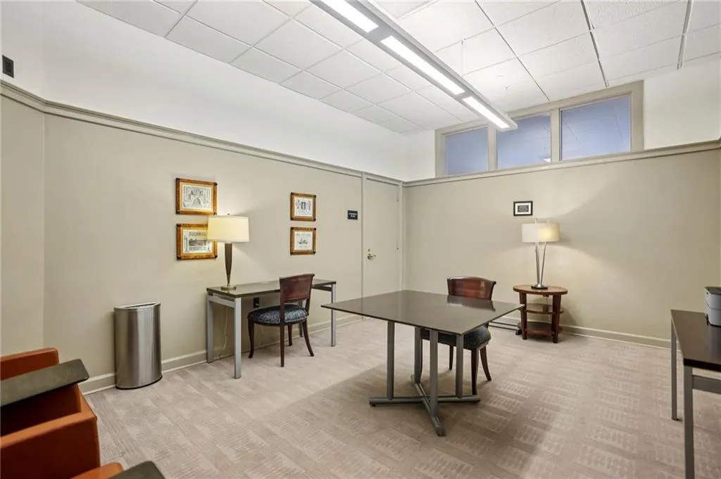 Spacious room featuring neutral wall tones with white trim and a patterned carpet