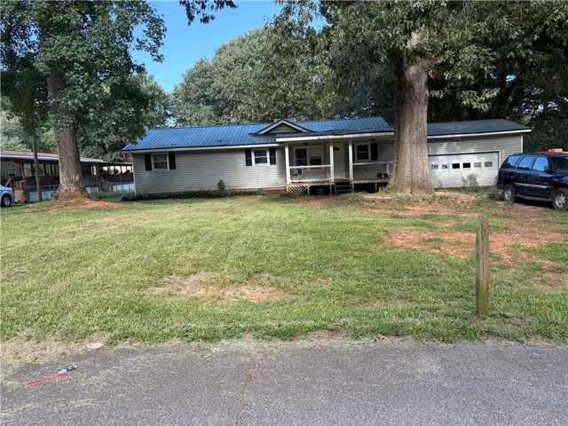 Single-story residence featuring a blue metal roof, horizontal siding, and a covered front porch