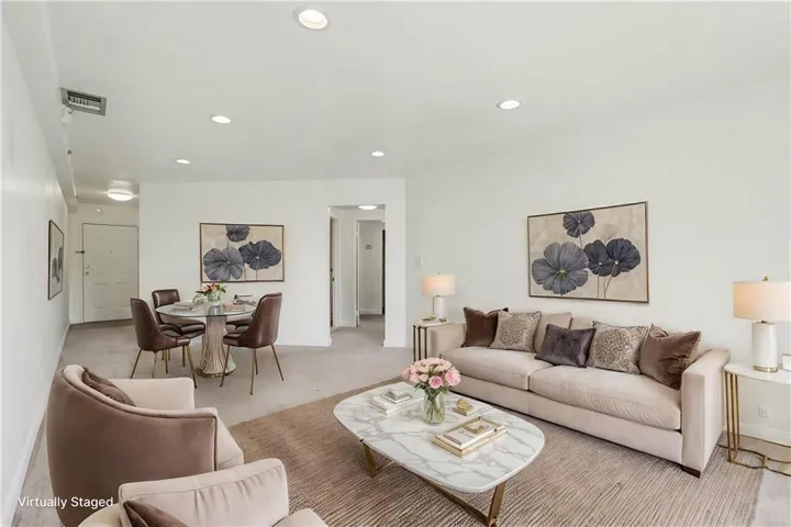 Open concept living area featuring recessed lighting, light-colored carpeting, and neutral wall paint