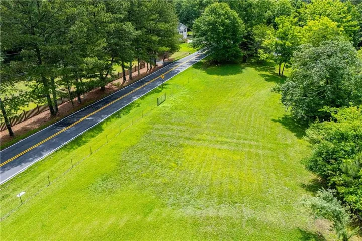 Expansive green lawn bordering a paved roadway with painted double yellow lines