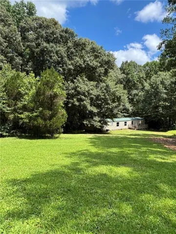 Front yard view from the road.  Surrounding mature trees for privacy.