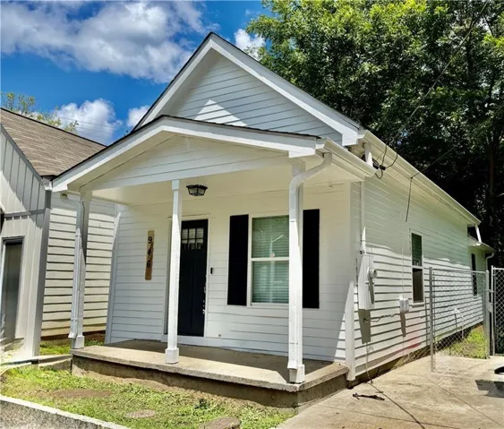 White siding exterior with a covered porch, black front door, and dark shutters