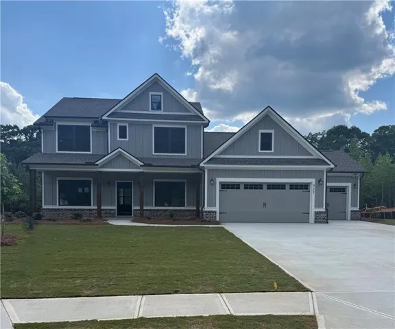 Two-story exterior with gray siding, multiple gables, and a prominent front porch with dark columns