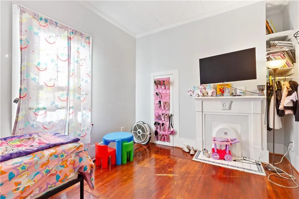 Bedroom featuring dark hardwood / wood-style flooring and crown molding