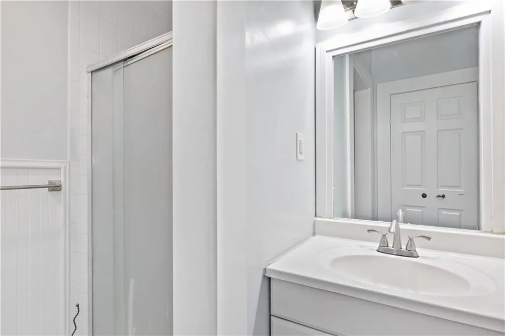 Bathroom with a shower with shower door and vanity