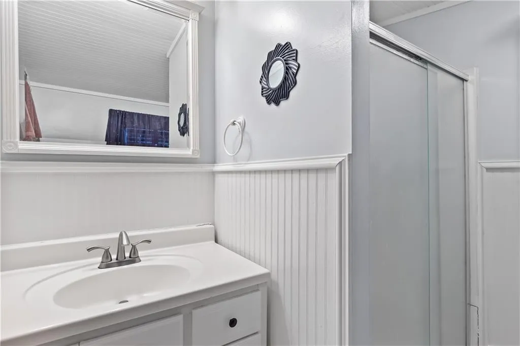 Bathroom featuring large vanity and an enclosed shower