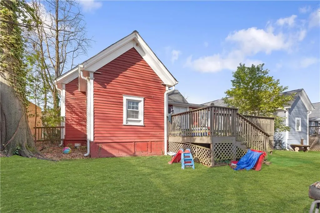 Rear view of property with a deck and a yard