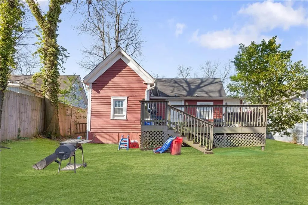 Back of property featuring a deck and a lawn
