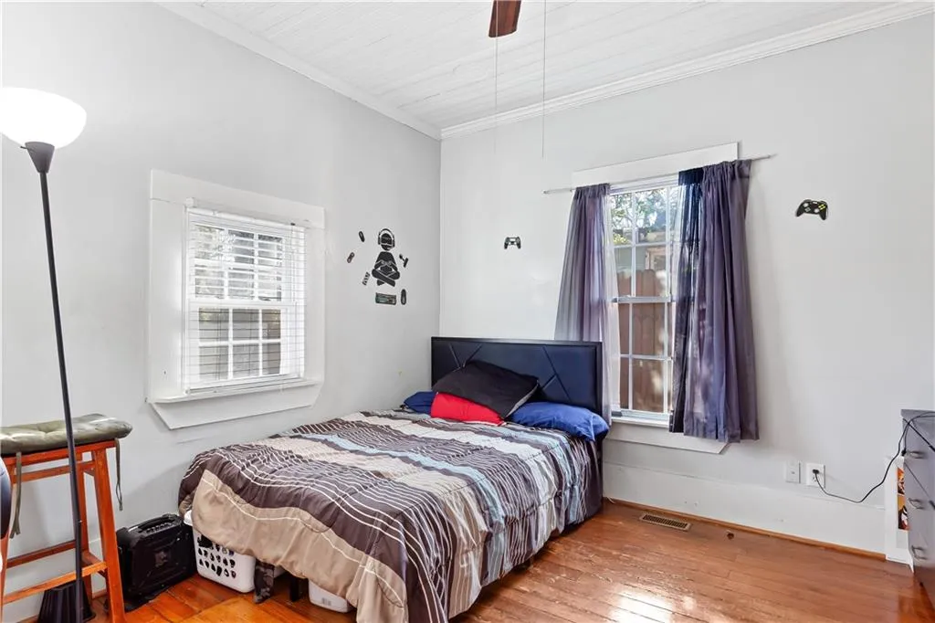 Bedroom featuring ornamental molding, light hardwood / wood-style floors, and ceiling fan