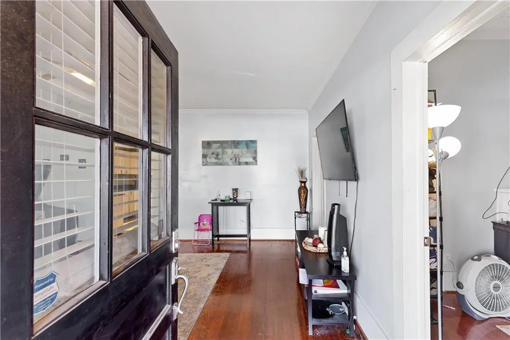 Hall with dark hardwood / wood-style flooring and crown molding