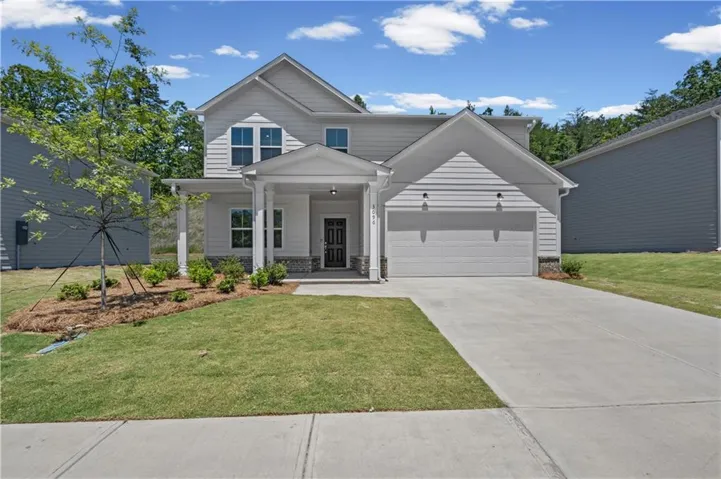 Contemporary residence with a two-car garage, covered entry porch, mixed siding and stone facade, and a concrete driveway