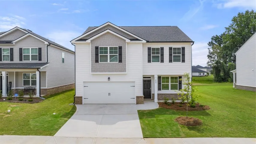 Craftsman house with a garage, concrete driveway, a front lawn, brick siding, and a porch