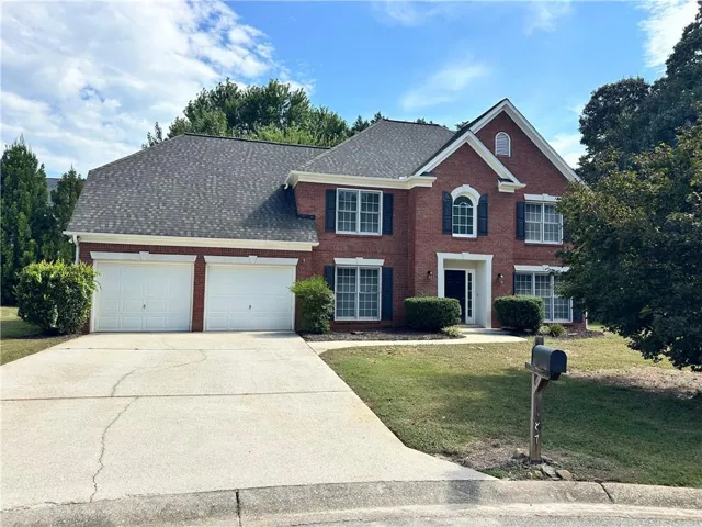 Brick exterior with a gabled roofline, two-car garage, and established landscaping