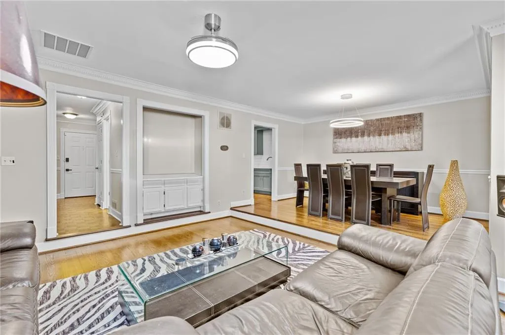 Living area featuring light wood-style flooring and crown molding