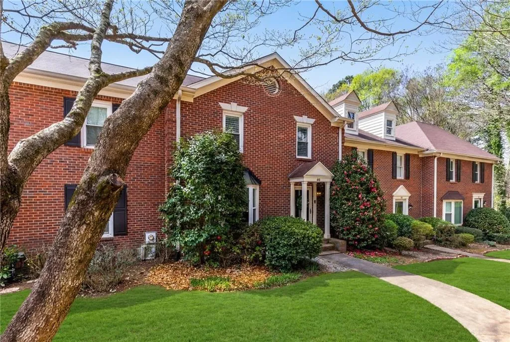View of front of house featuring a front lawn and brick siding