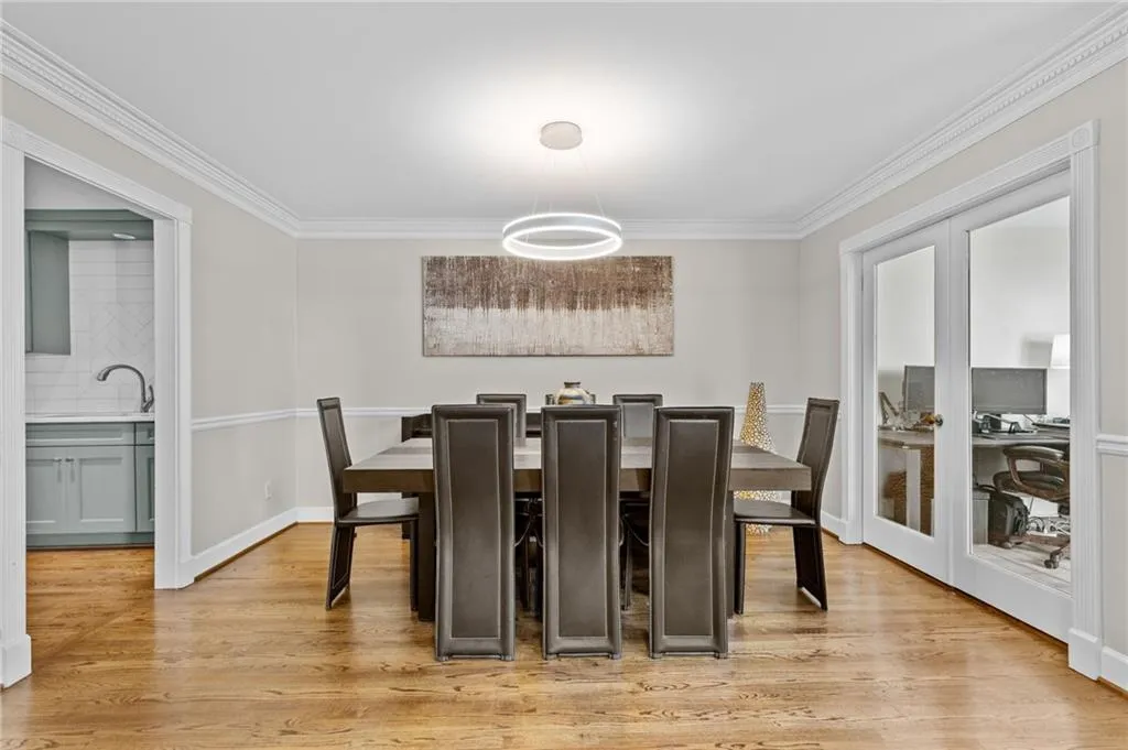 Dining room with crown molding and light wood-style flooring