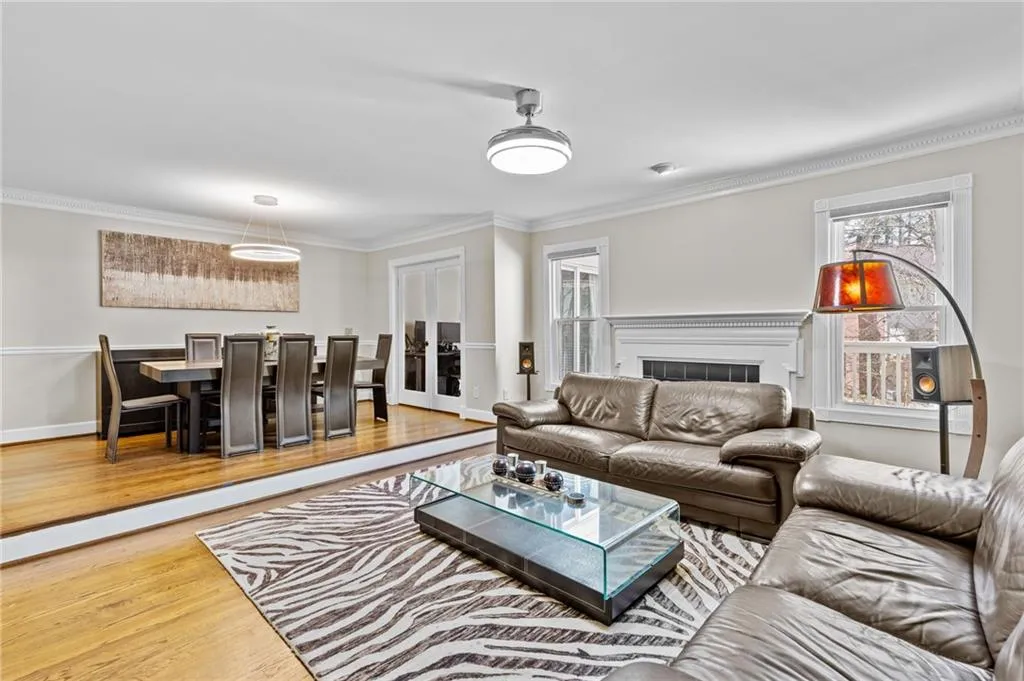 Living area featuring ornamental molding, wood finished floors, and a fireplace