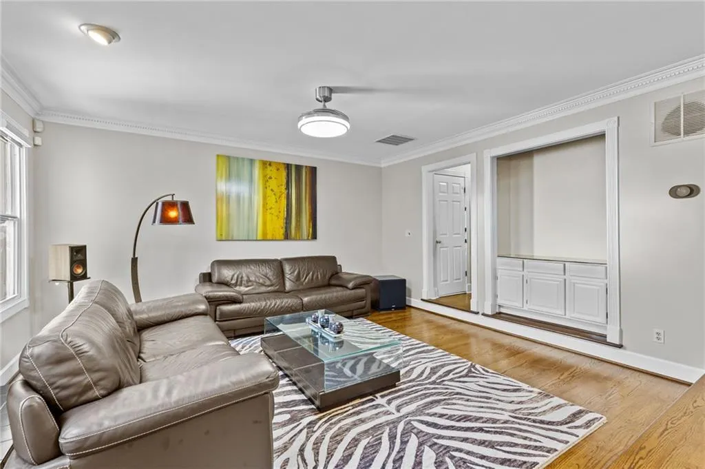 Living room with crown molding and light wood finished floors