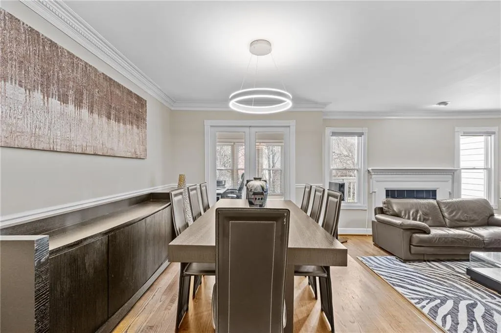 Dining space with ornamental molding, light wood-type flooring, and a fireplace