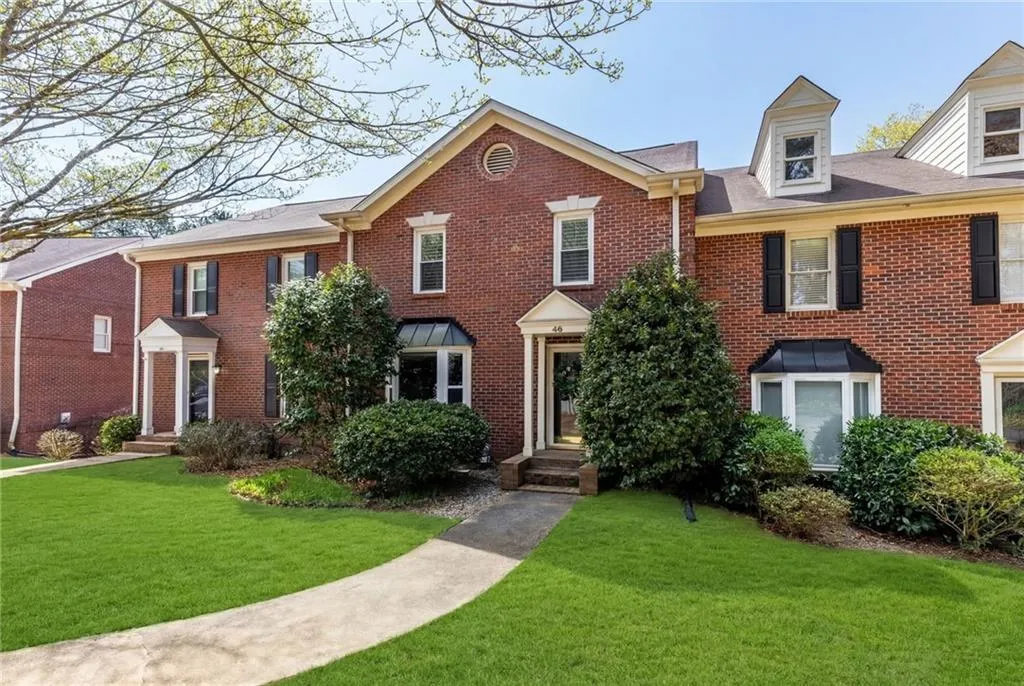 Colonial house with a front yard and brick siding