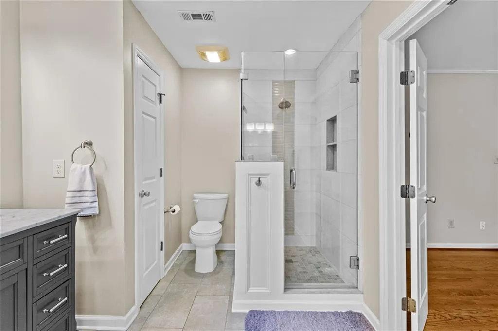 Full bath with vanity, a stall shower, recessed lighting, and light tile patterned floors