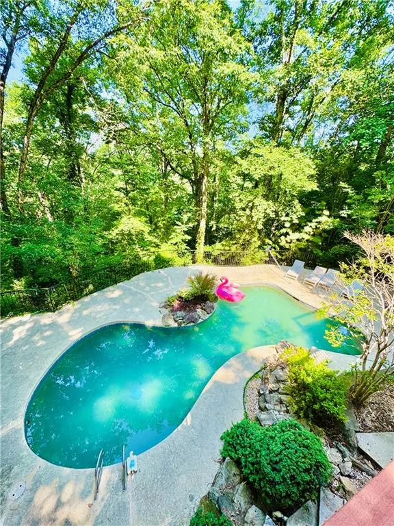 Swimming pool with a fenced backyard and a patio area