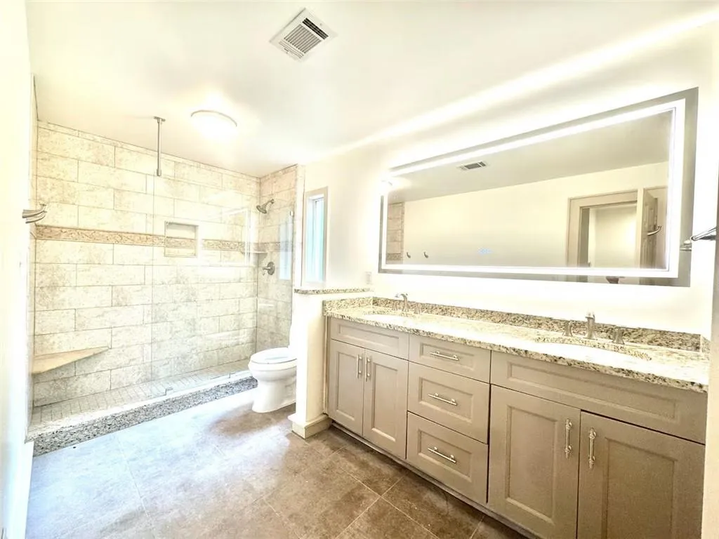 Bathroom with double vanity and a tile shower