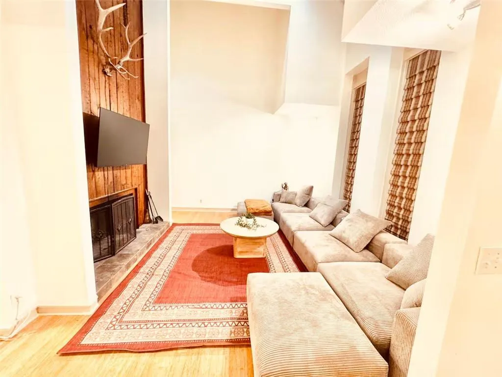Living area with wood finished floors and a tiled fireplace