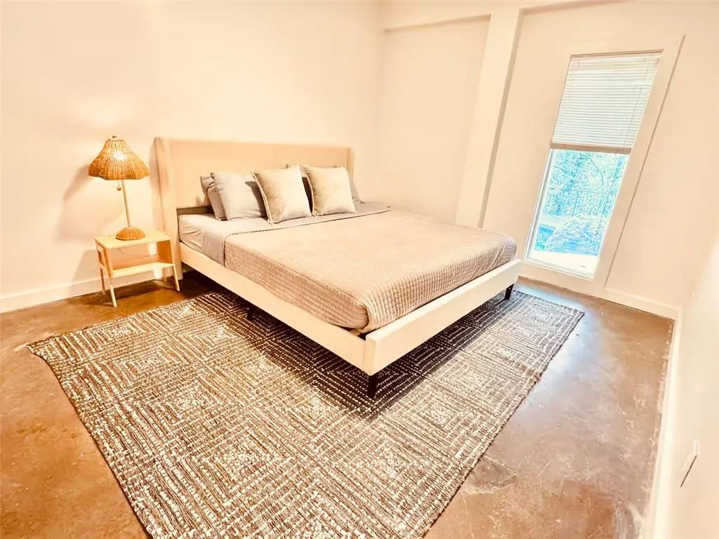 Bedroom featuring baseboards and concrete flooring